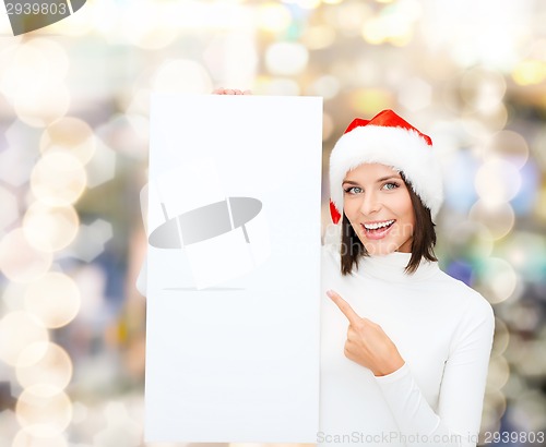 Image of smiling young woman in santa hat with white board