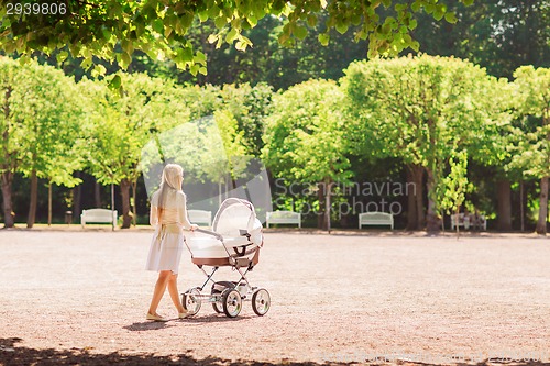 Image of happy mother with stroller in park