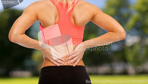 Image of close up of sporty woman touching her back