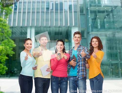 Image of group of teenagers with smartphones and tablet pc