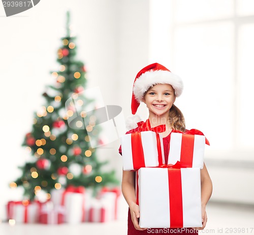 Image of girl in santa helper hat with many gift boxes