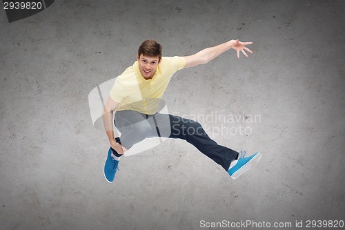 Image of smiling young man jumping in air