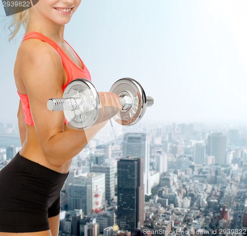 Image of close up of sporty woman with heavy steel dumbbell