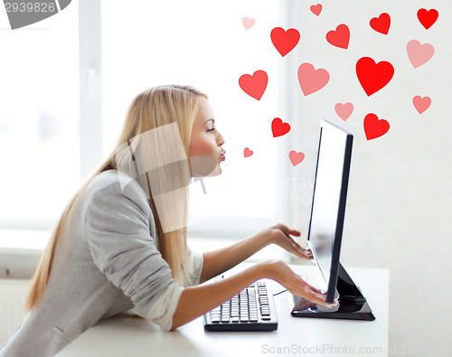 Image of woman sending kisses with computer monitor