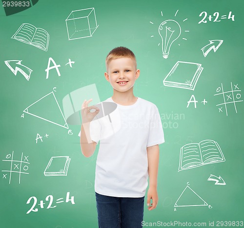 Image of little boy in white t-shirt making ok gesture