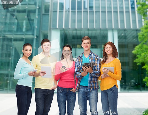 Image of group of teenagers with smartphones and tablet pc