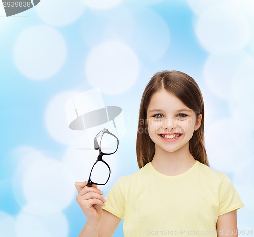 Image of smiling cute little girl holding black eyeglasses