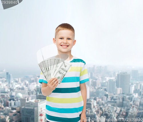 Image of smiling boy holding dollar cash money in his hand