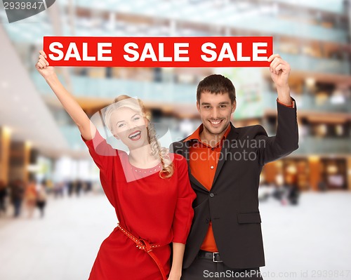 Image of smiling couple with red sale sign