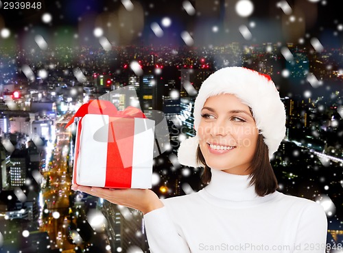 Image of smiling woman in santa helper hat with gift box