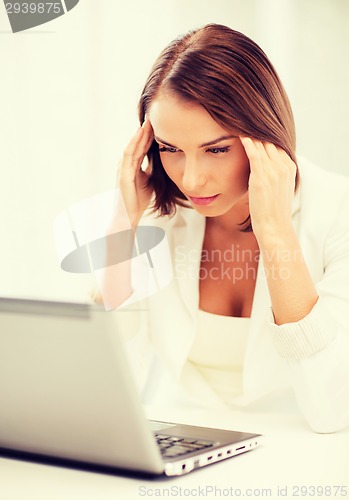 Image of businesswoman with laptop in office