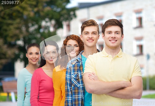 Image of group of smiling teenagers over campus background