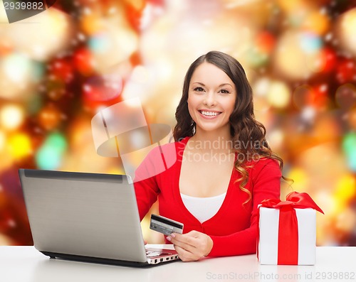 Image of smiling woman with credit card and laptop
