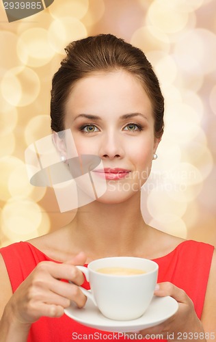 Image of smiling woman in red dress with cup of coffee