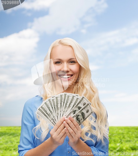 Image of smiling young woman with us dollar money