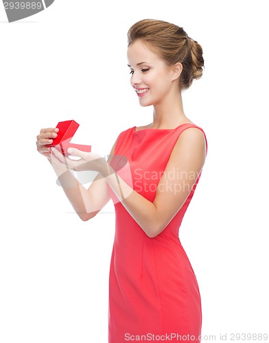Image of smiling young woman in red dress with gift box