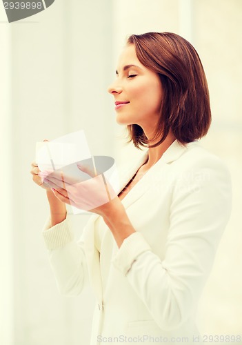 Image of businesswoman with cup of coffee in office