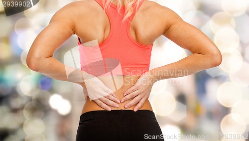 Image of close up of sporty woman touching her back