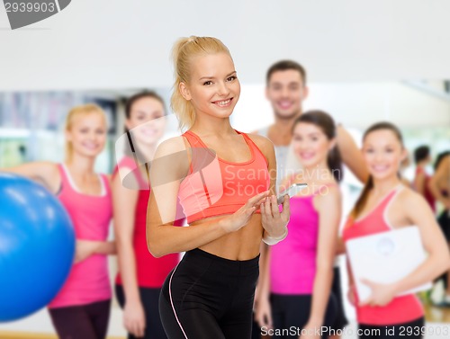 Image of smiling sporty woman with smartphone