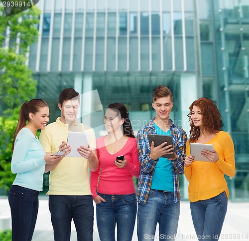 Image of group of teenagers with smartphones and tablet pc