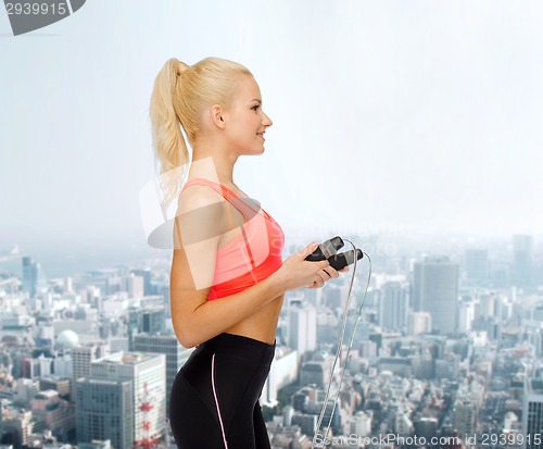 Image of smiling sporty woman with skipping rope