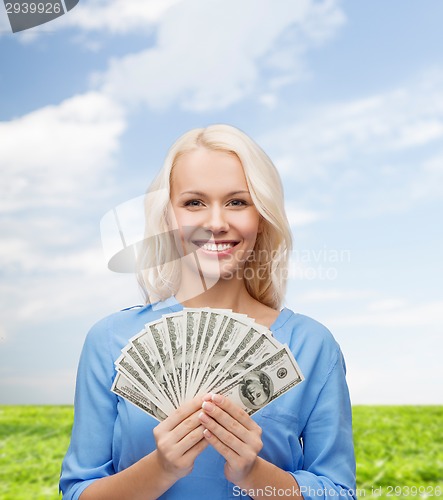 Image of smiling young woman with us dollar money