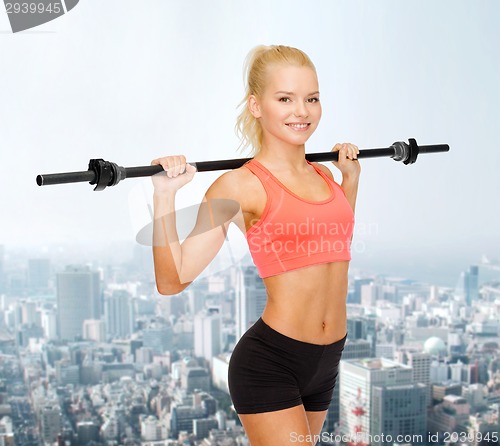 Image of smiling sporty woman exercising with barbell