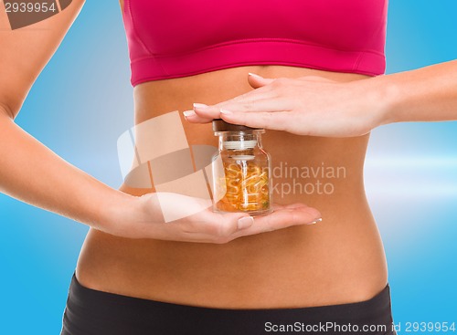 Image of close up of female hands with bottle of capsules