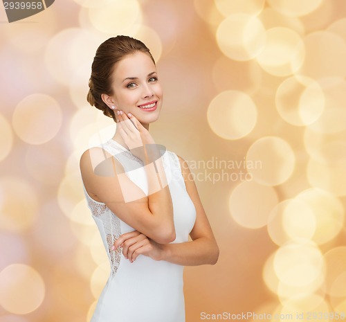 Image of smiling woman in white dress wearing diamond ring