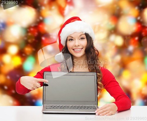 Image of smiling woman in santa helper hat with laptop