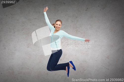 Image of smiling young woman jumping in air