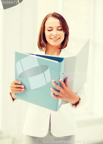 Image of businesswoman with folders in office