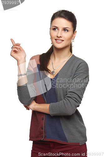 Image of Woman in cardigan pointing at blank copy space