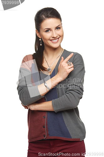 Image of Woman in cardigan pointing at blank copy space