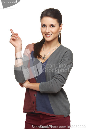 Image of Woman in cardigan pointing at blank copy space