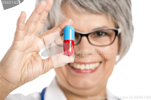 Image of Female doctor holding  a pill