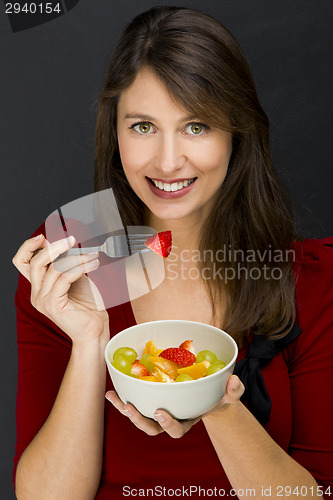 Image of Woman eating a fruit salad