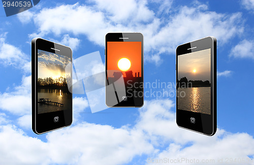 Image of three mobile phones with different sunsets
