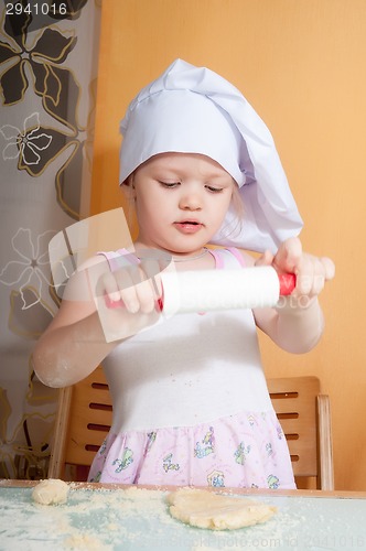 Image of baby girl in cook role on kitchen