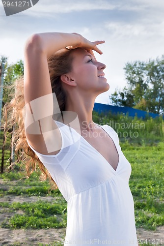 Image of Attractive young woman in white dress
