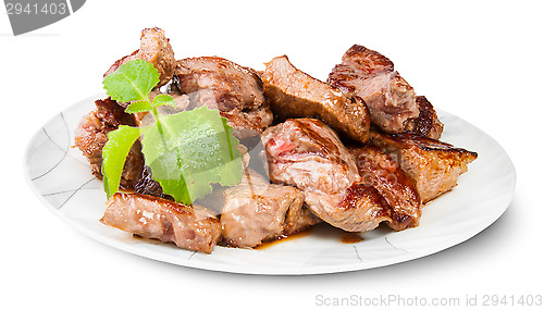 Image of Grilled Meat On A White Plate Served With Mint Leaf