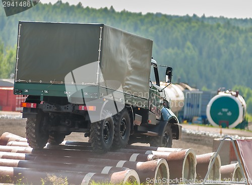 Image of Curtain sided truck moves on obstacle from pipes