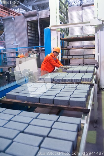 Image of Worker at machine on stone blocks drying