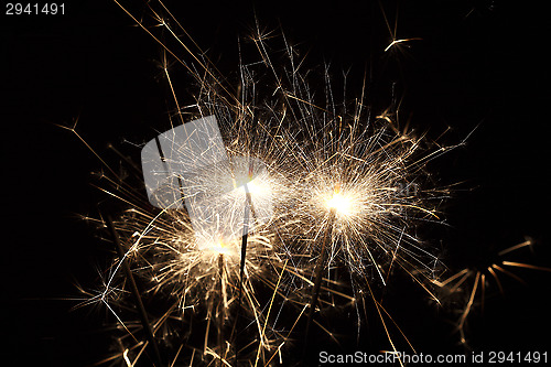 Image of Burning sparklers on black background