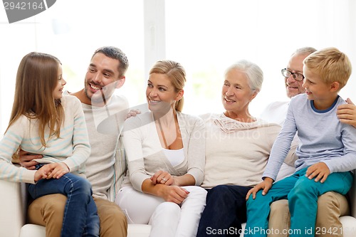 Image of happy family sitting on couch at home