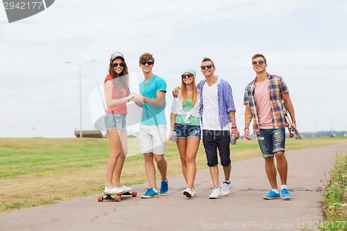 Image of group of smiling teenagers with skateboards