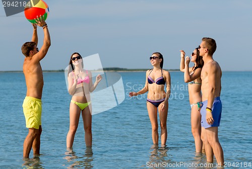 Image of smiling friends in sunglasses on summer beach