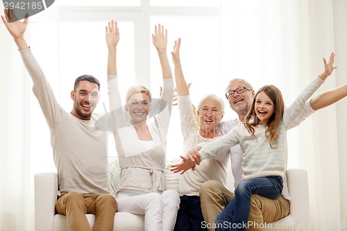 Image of happy family sitting on sofa at home