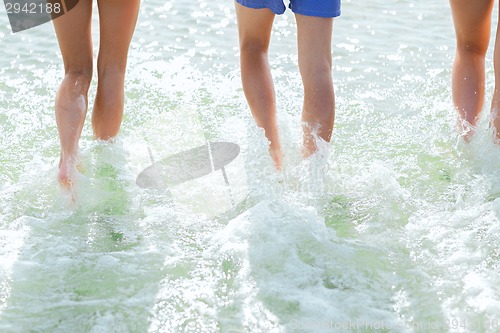 Image of close up of human legs on summer beach