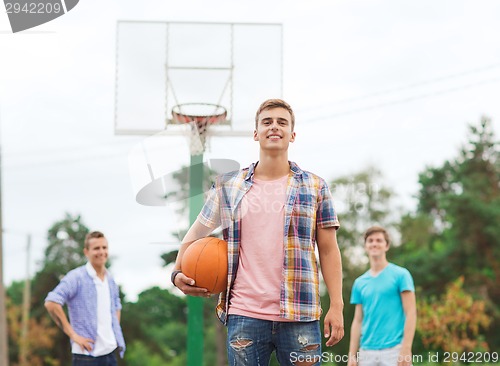 Image of group of smiling teenagers playing basketball